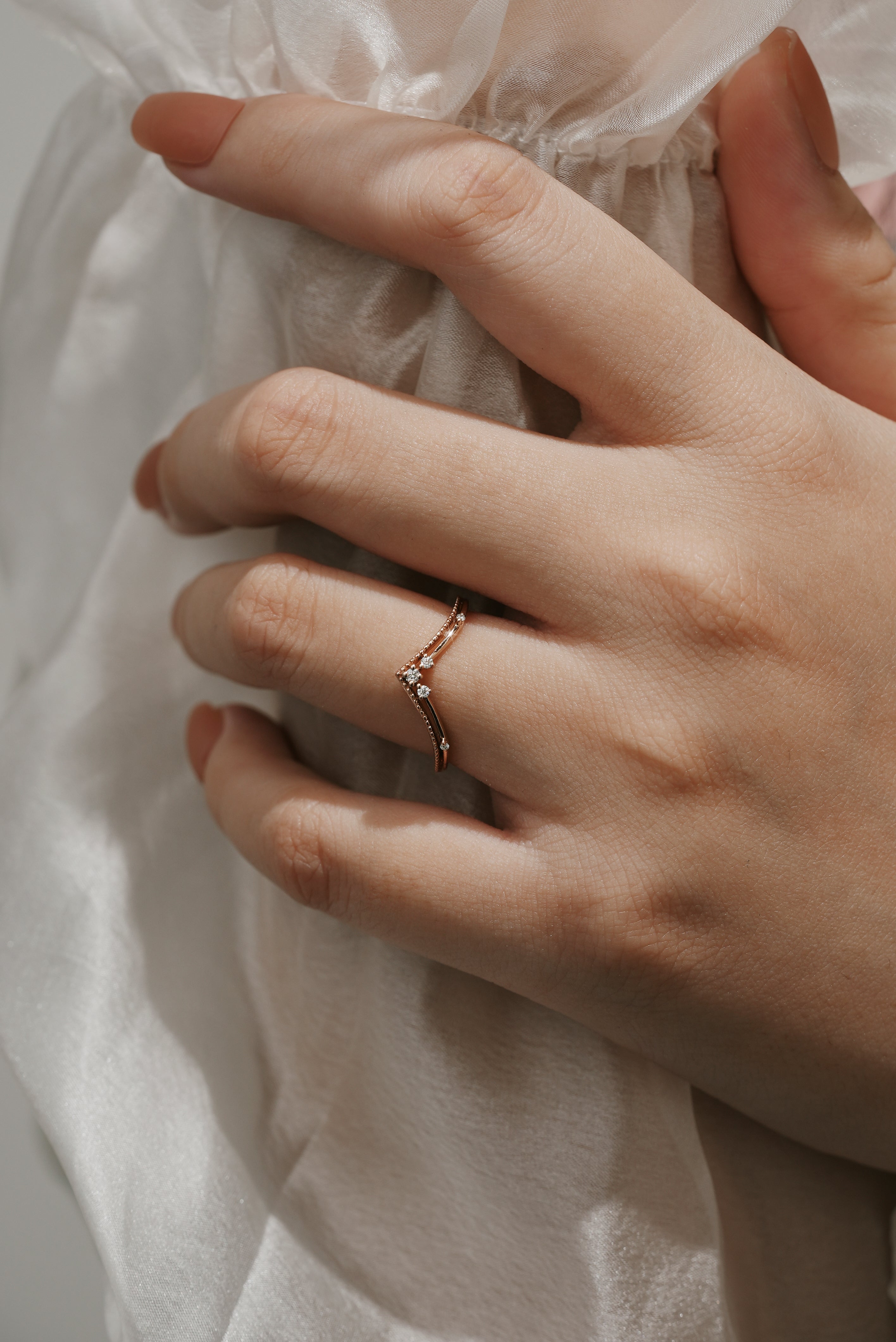 Rose gold curved moissanite wedding band on hand