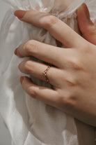 Rose gold curved moissanite wedding band on hand