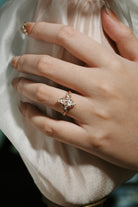 Rose gold leaf engagement ring with coffin-cut moissanite on a hand