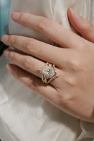 Woman's hand wearing pear cut halo moissanite engagement ring set, Lahela Jewelry