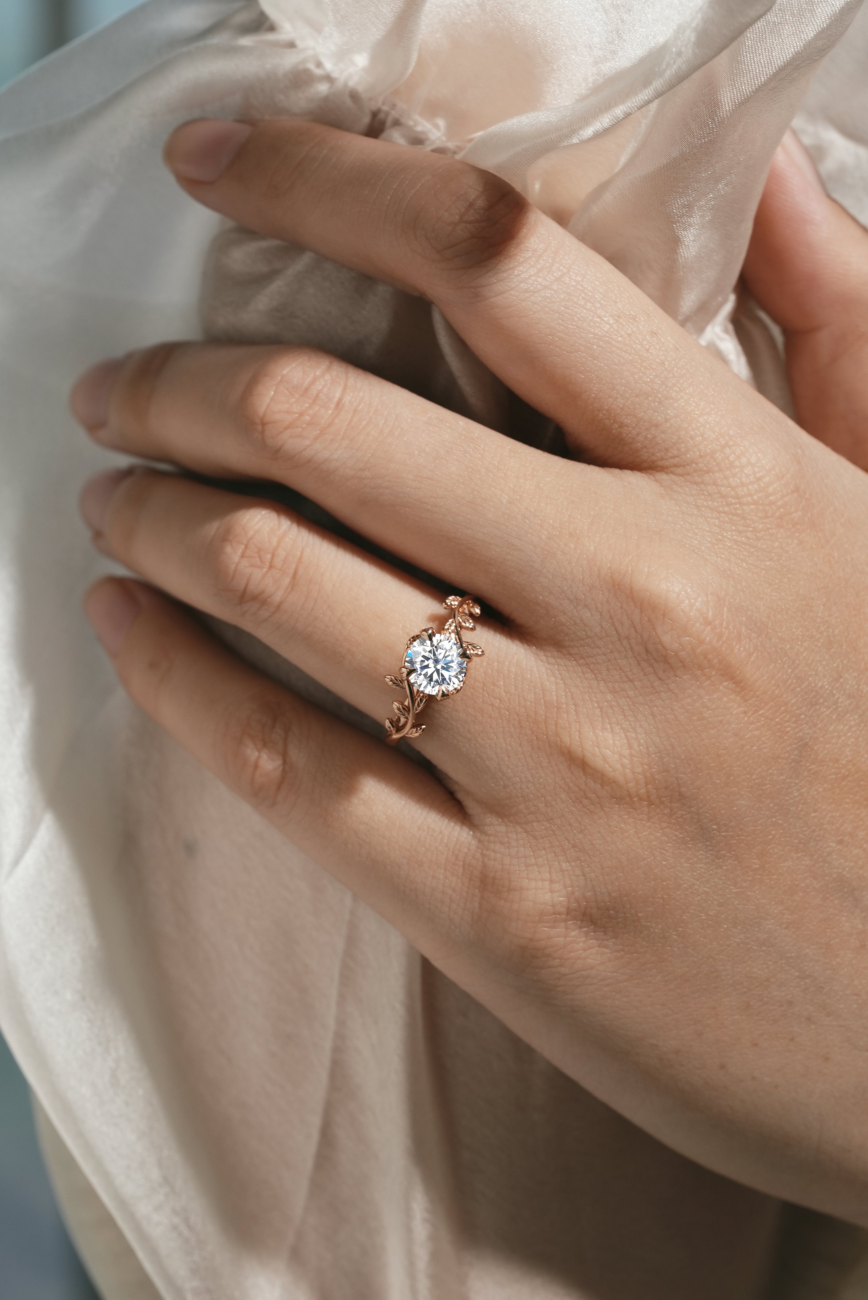 Rose gold leaf engagement ring on a hand