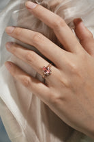 Vintage Padparadscha sapphire engagement ring on a hand, rose gold