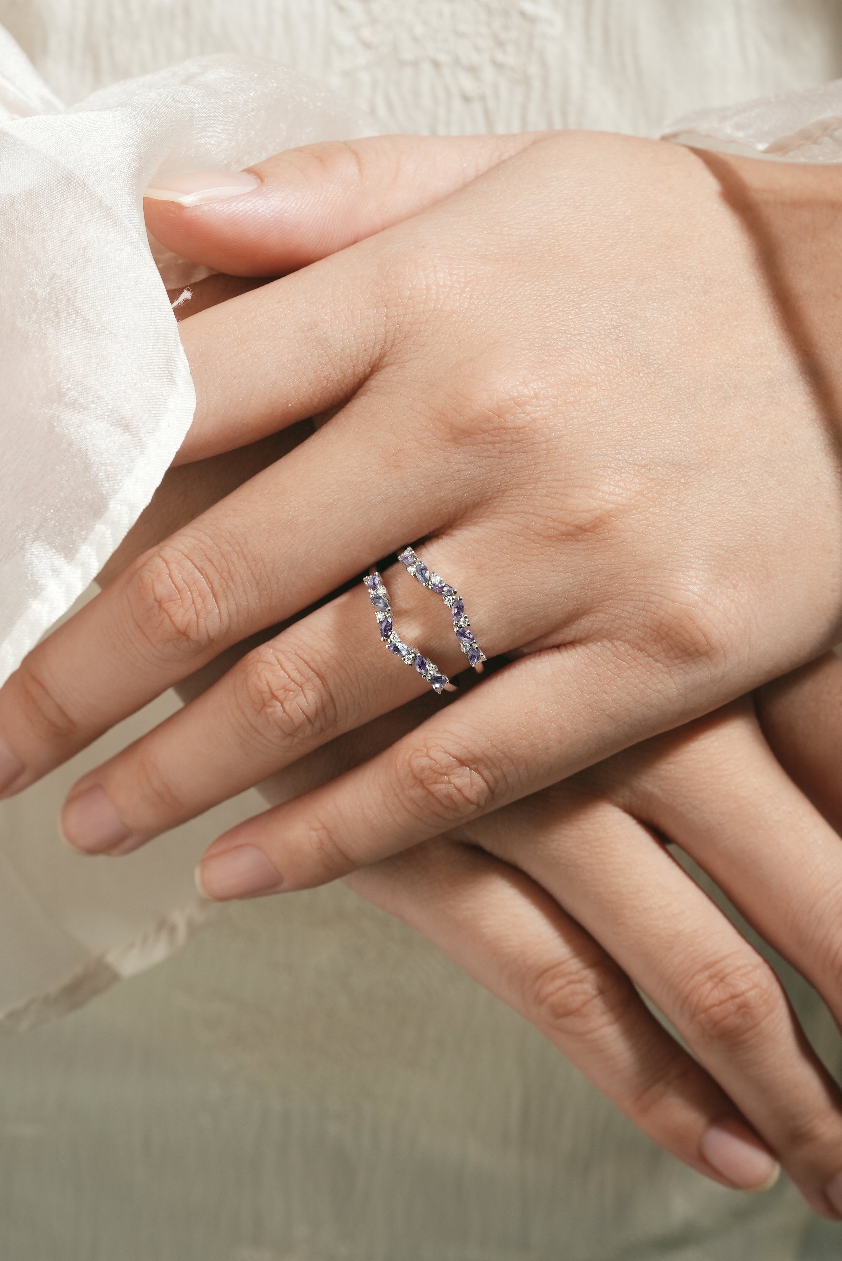 Alexandrite enhancer wedding band on a hand. Sterling silver bridal set with moissanite.