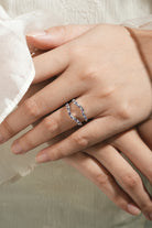 Alexandrite enhancer wedding band on a hand. Sterling silver bridal set with moissanite.