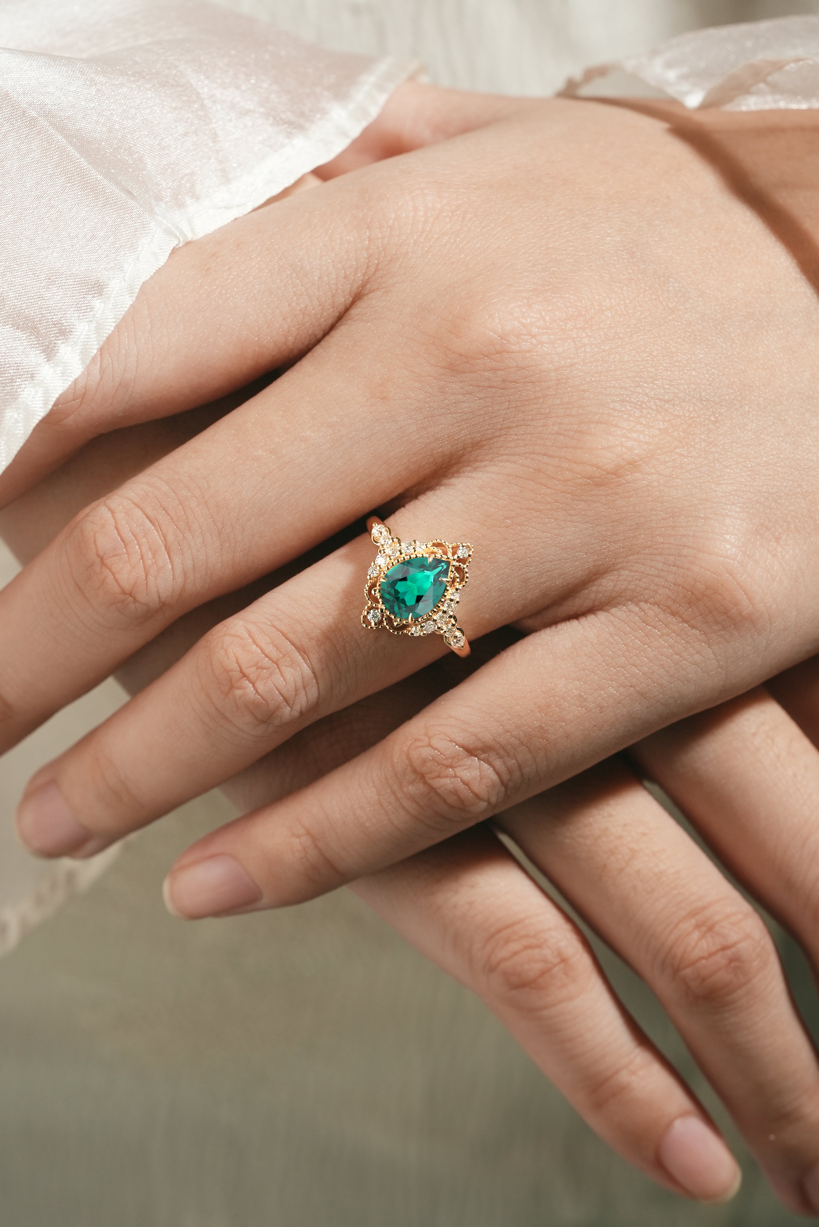 Hand wearing Pear Cut Emerald Palace Ring