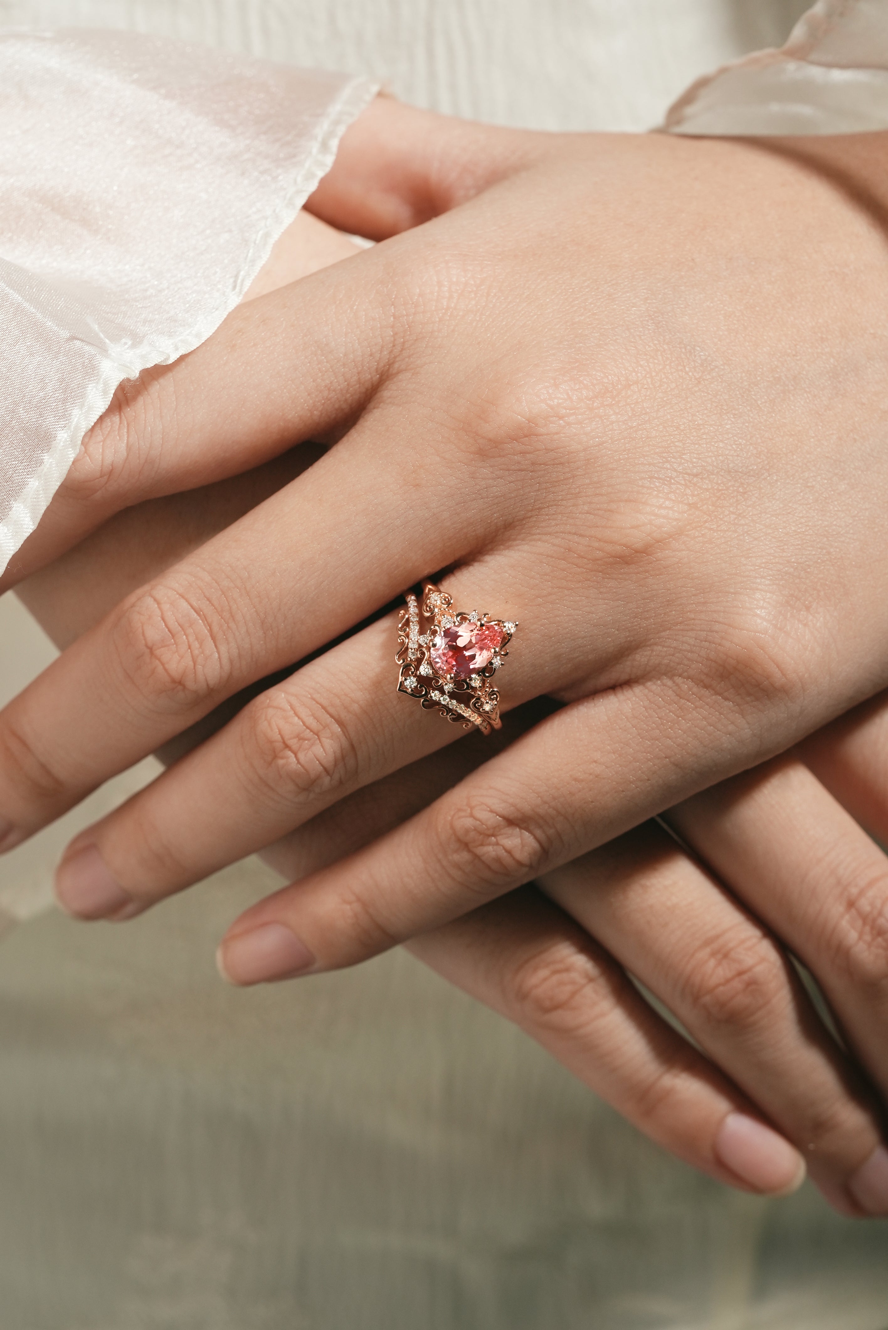 Rose gold engagement ring with Padparadscha sapphire on hand
