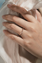 Rose gold V-shaped leaf moissanite wedding band on hand