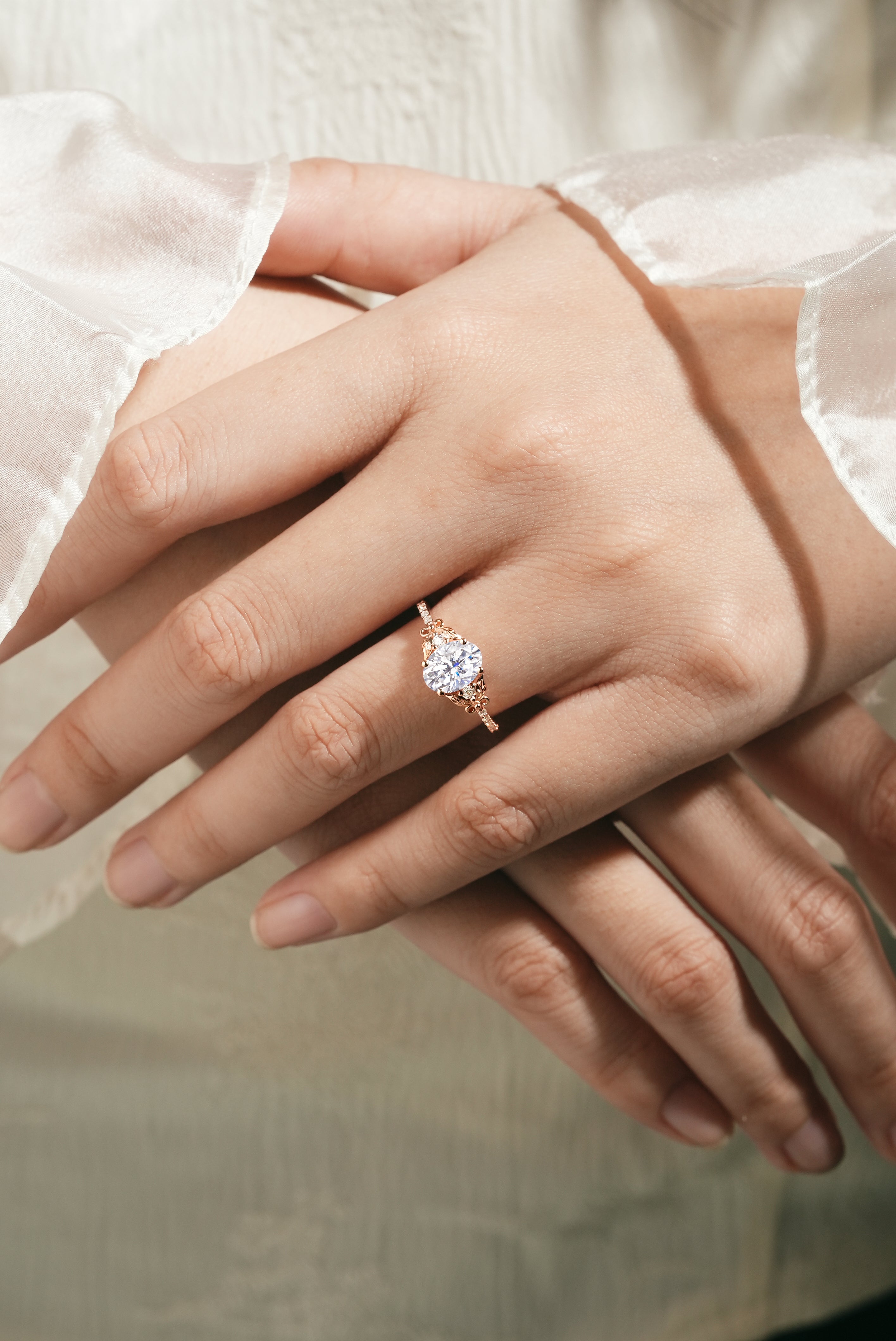 Rose gold leaf engagement ring with round moissanite on hand