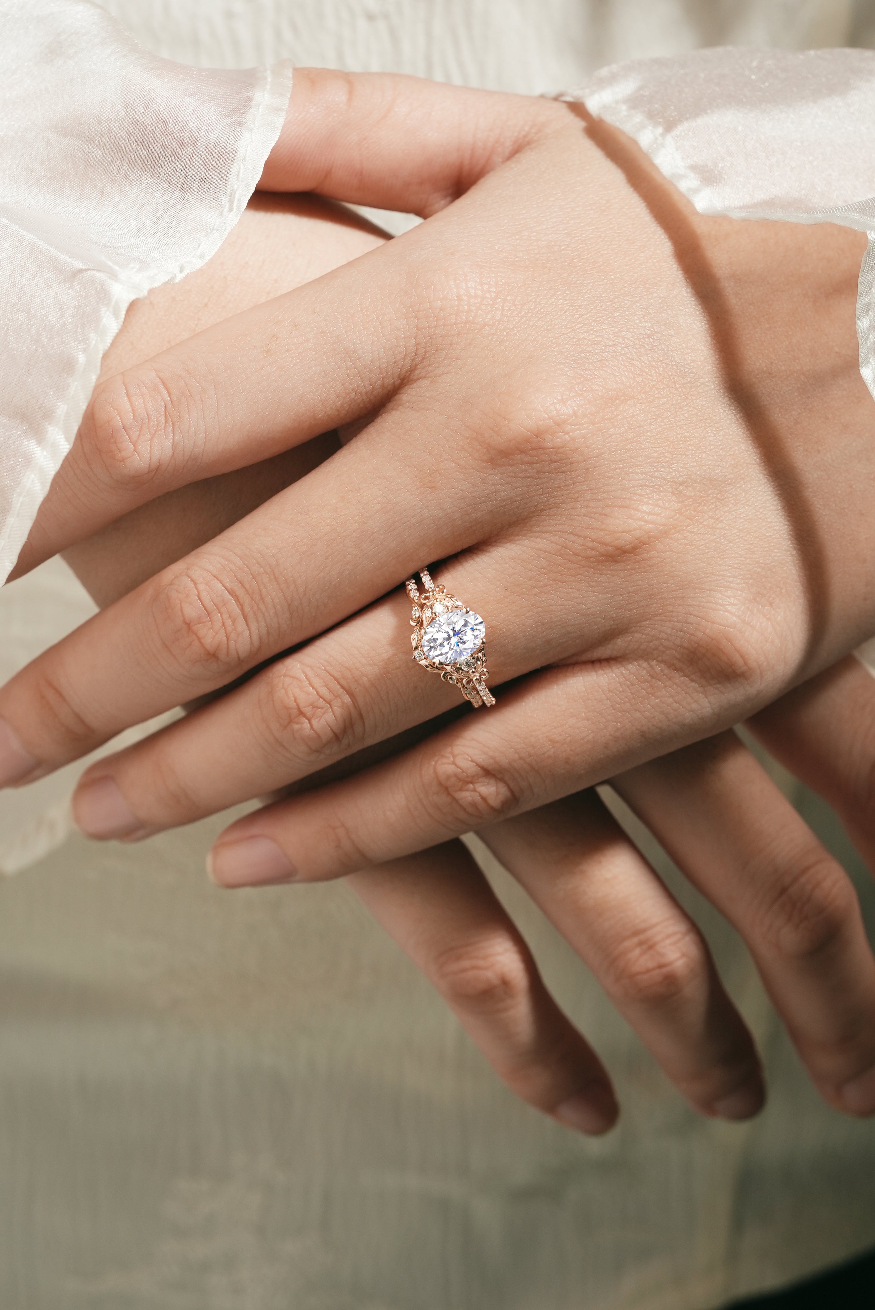 Oval moissanite ring set on hand with leaf details