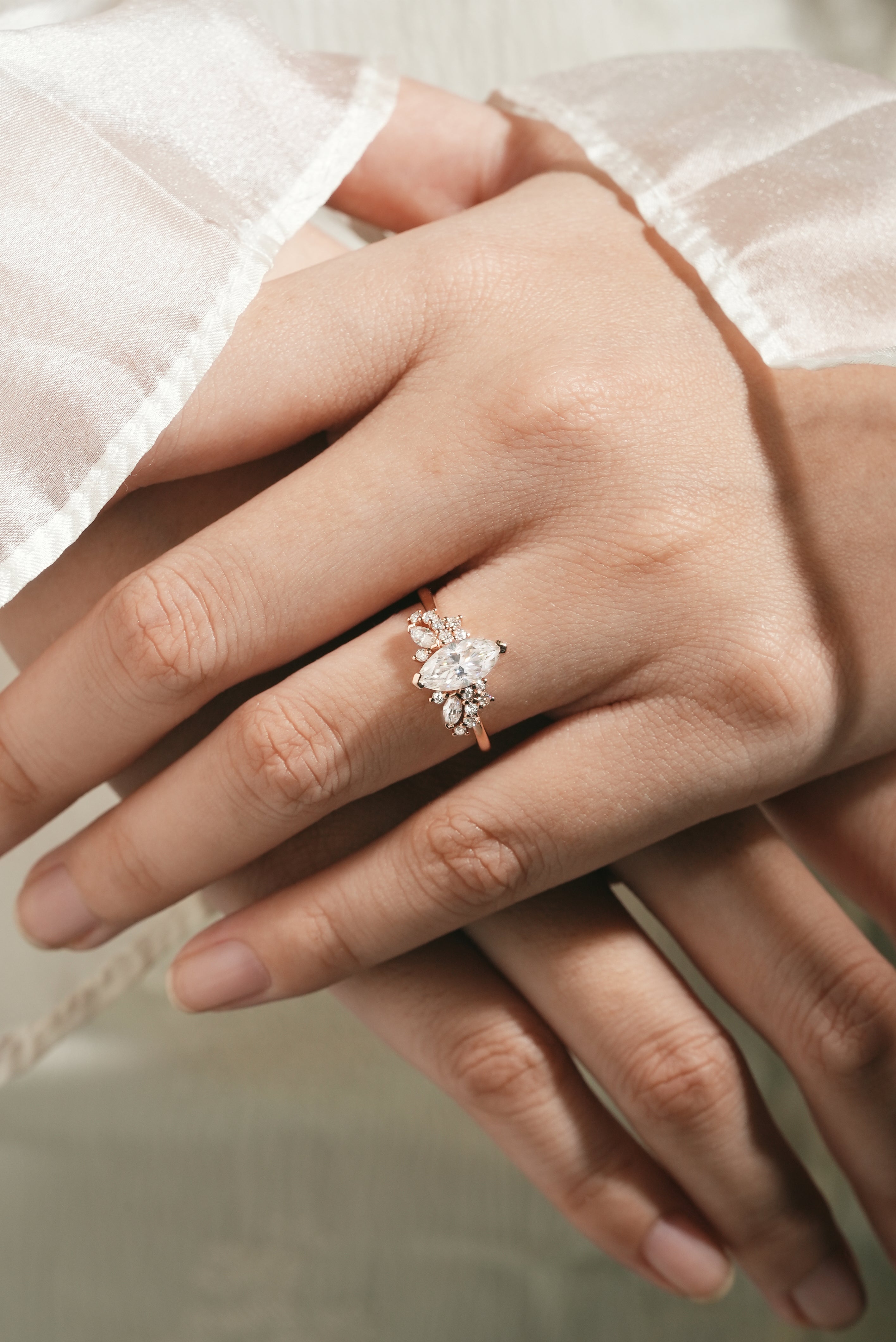 Rose gold marquise moissanite cluster engagement ring on hand