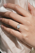 Rose gold oval moissanite ring with spinel cluster on hand