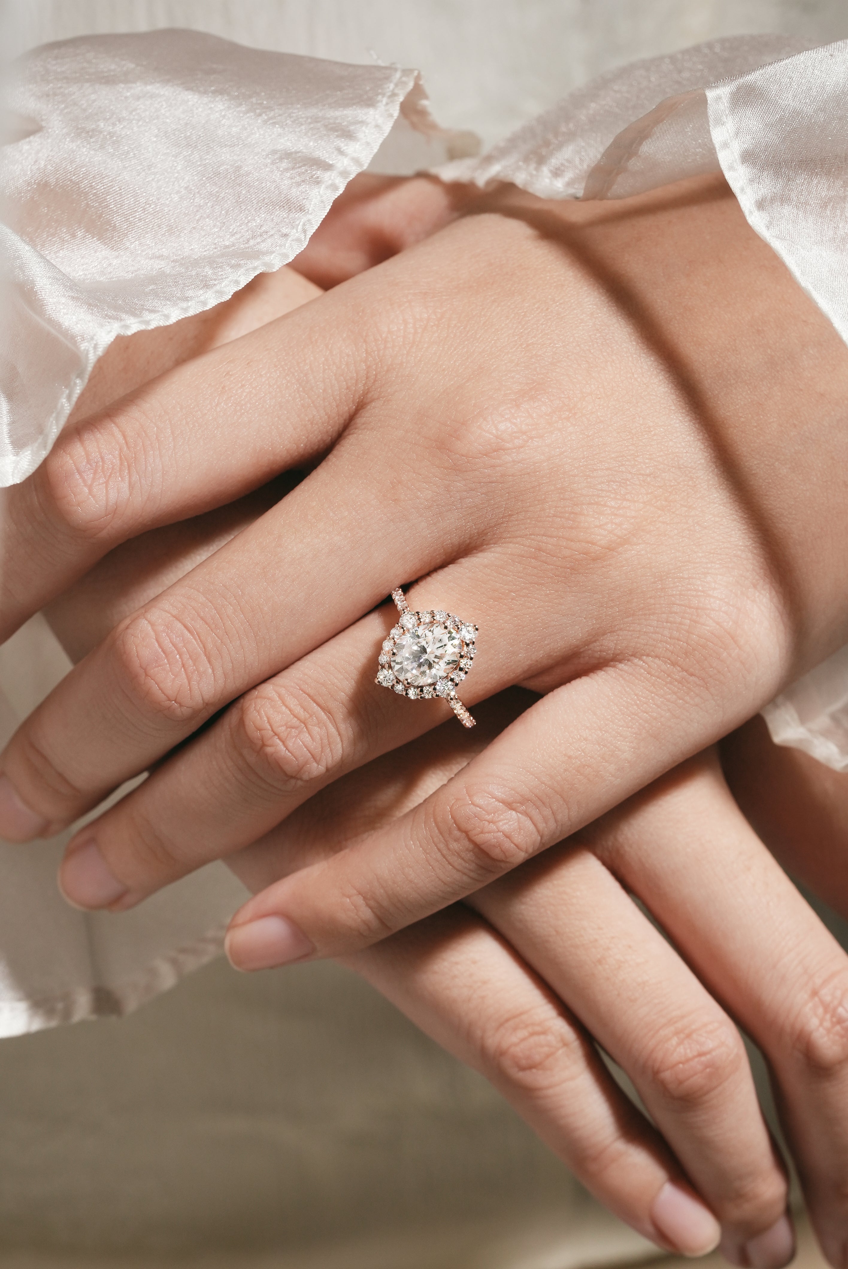 Woman's hand wearing oval cut moissanite halo engagement ring