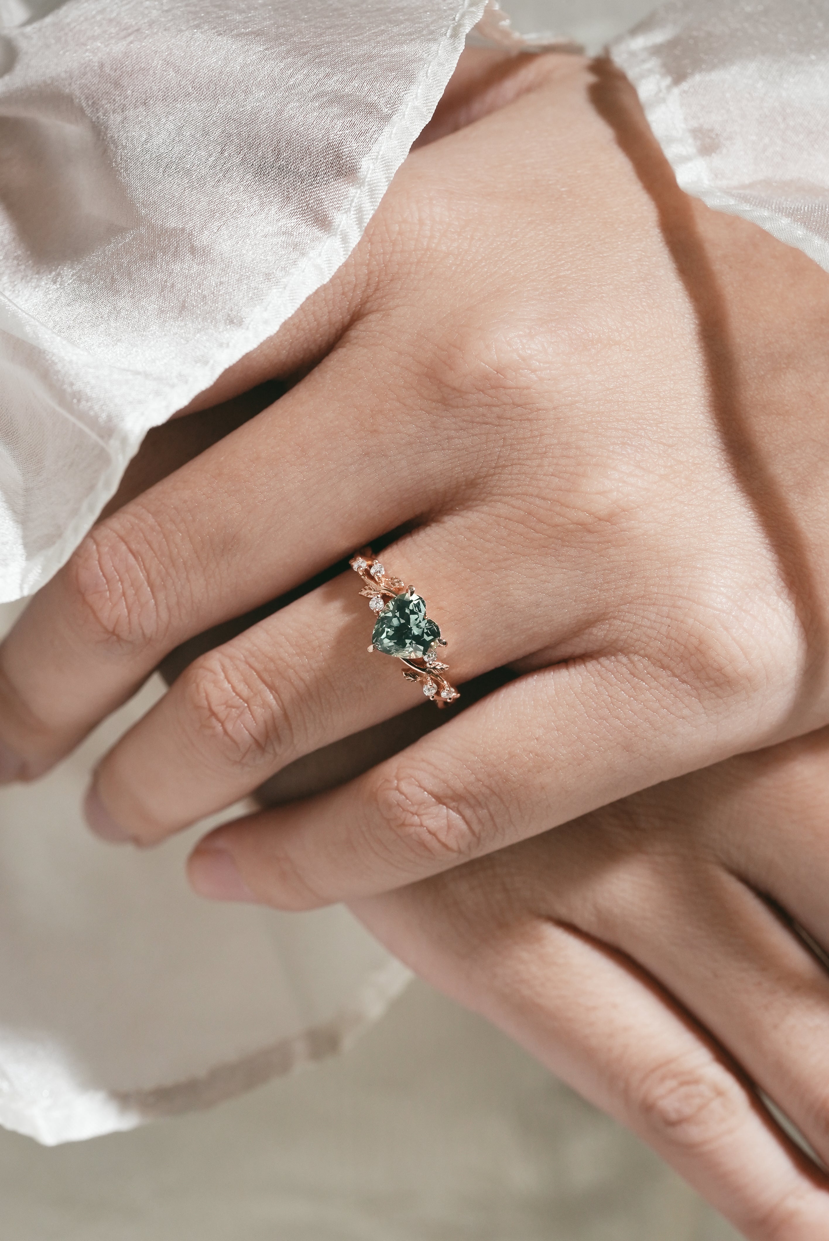 Woman's hand wearing green sapphire engagement ring, Lahela Jewelry