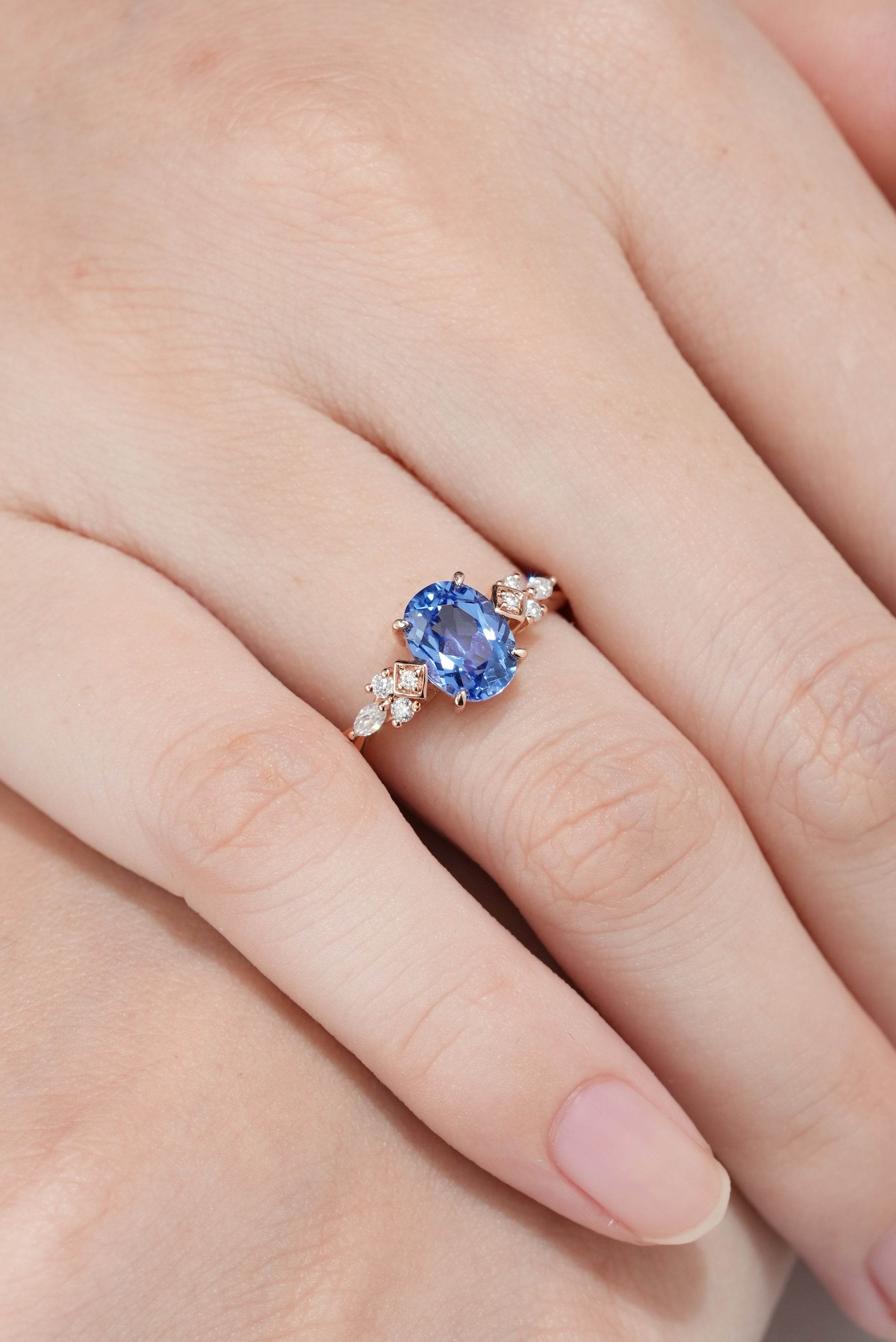 Art Deco Oval Cut Cornflower Sapphire Engagement Ring In A Woman's Finger