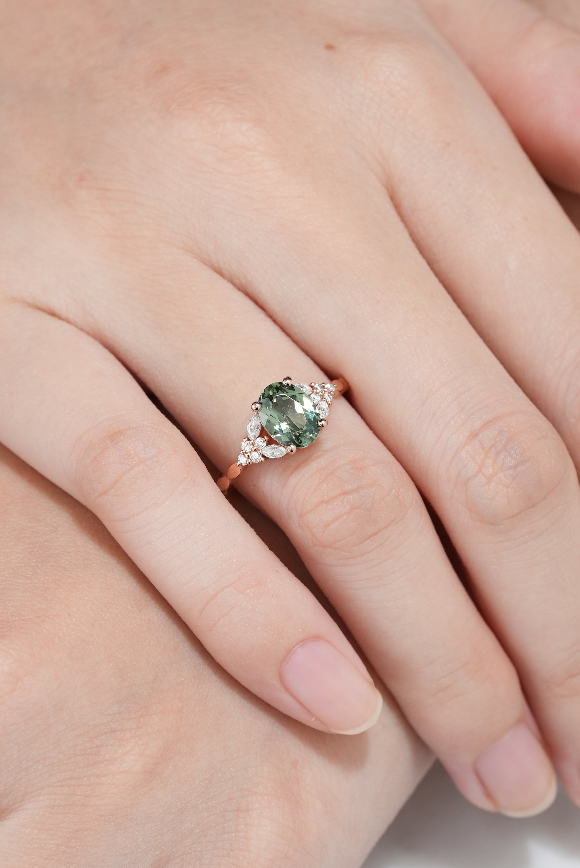 14K Rose Gold Oval Cut Green Sapphire Engagement Ring In A Hand