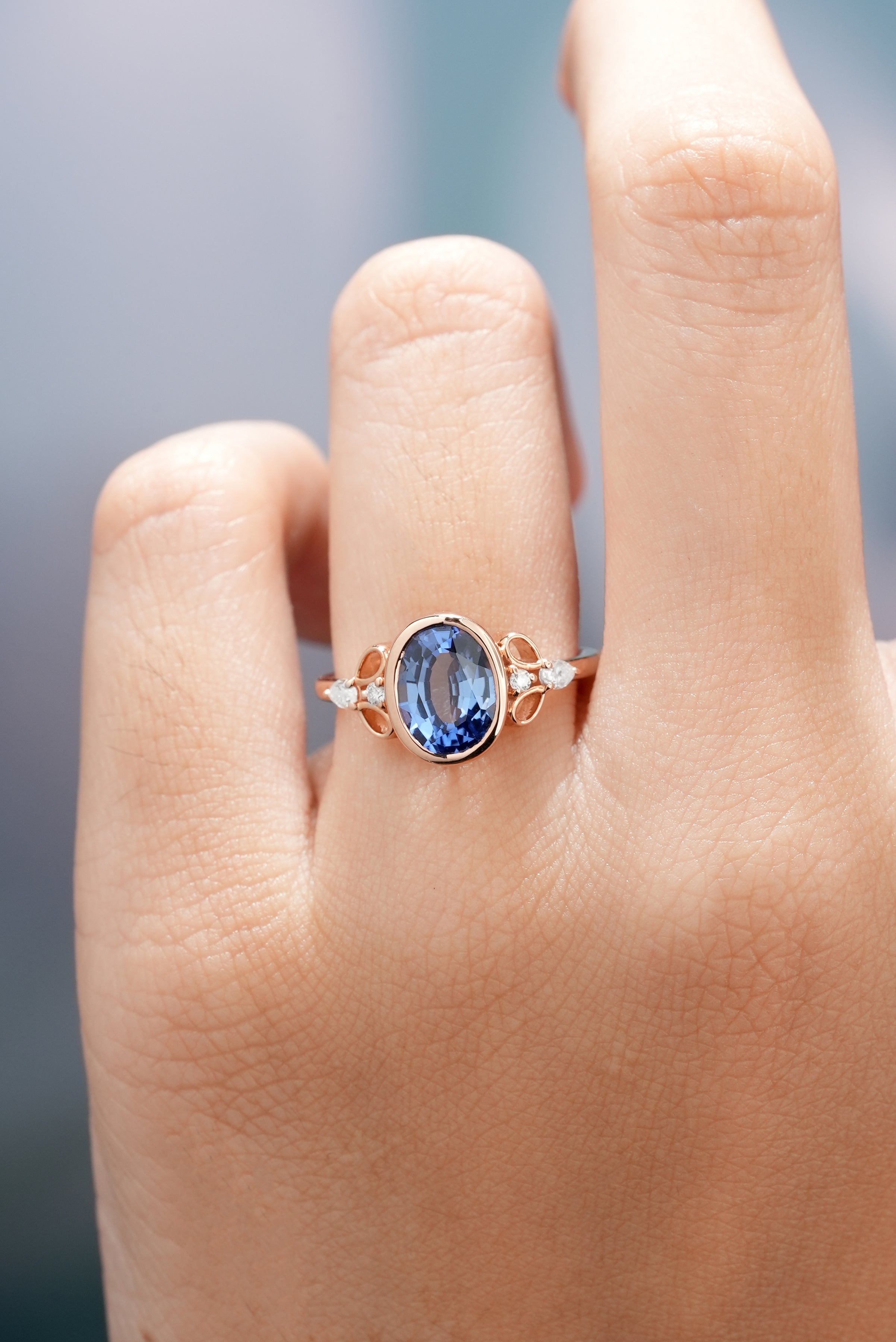 Dainty Oval Cut Blue Sapphire Engagement Ring In A Woman Finger