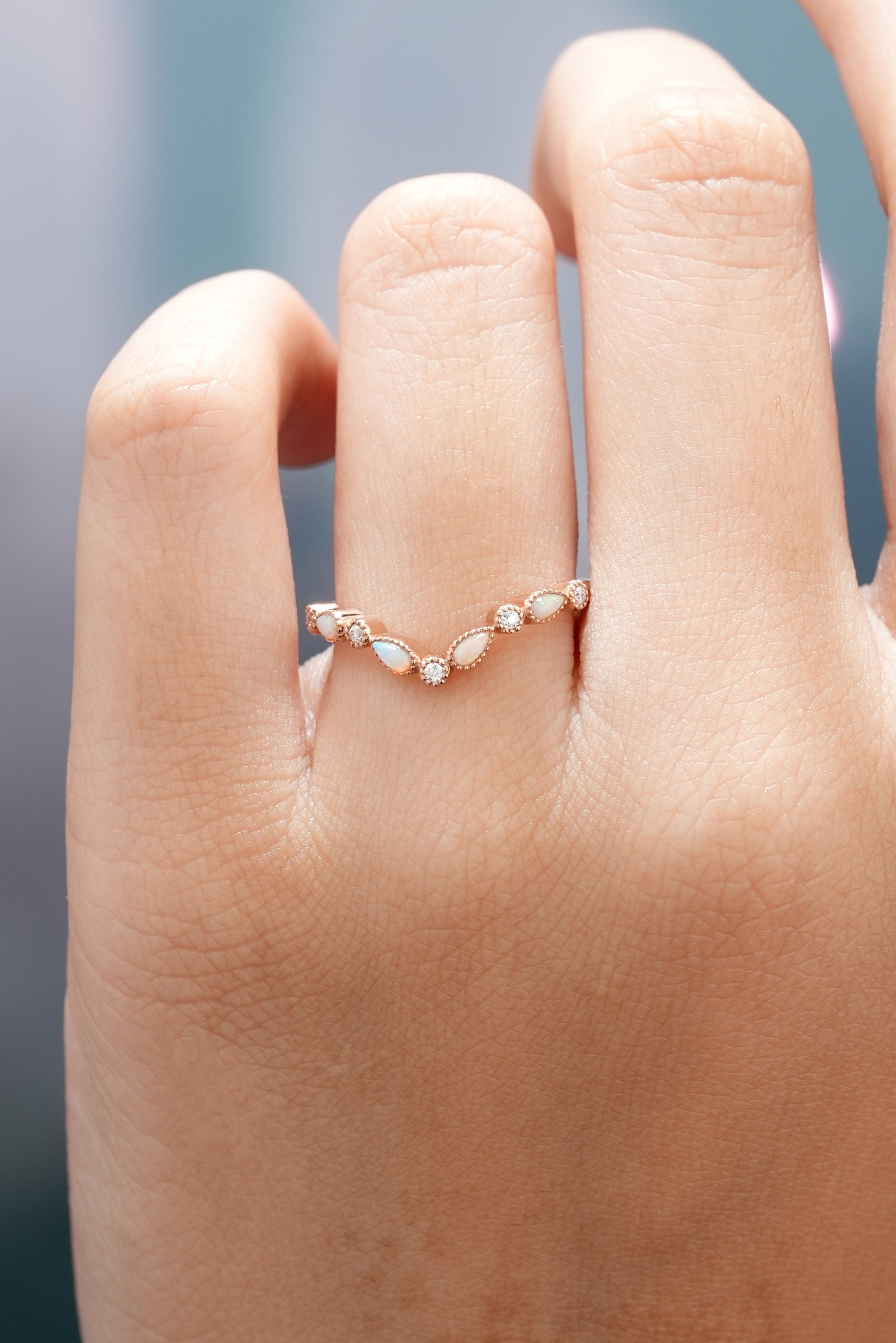 Hand wearing a Rose Gold Chevron Wedding Band with Opal and Moissanite