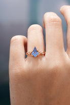 Rose gold kite cut sapphire engagement ring on a hand
