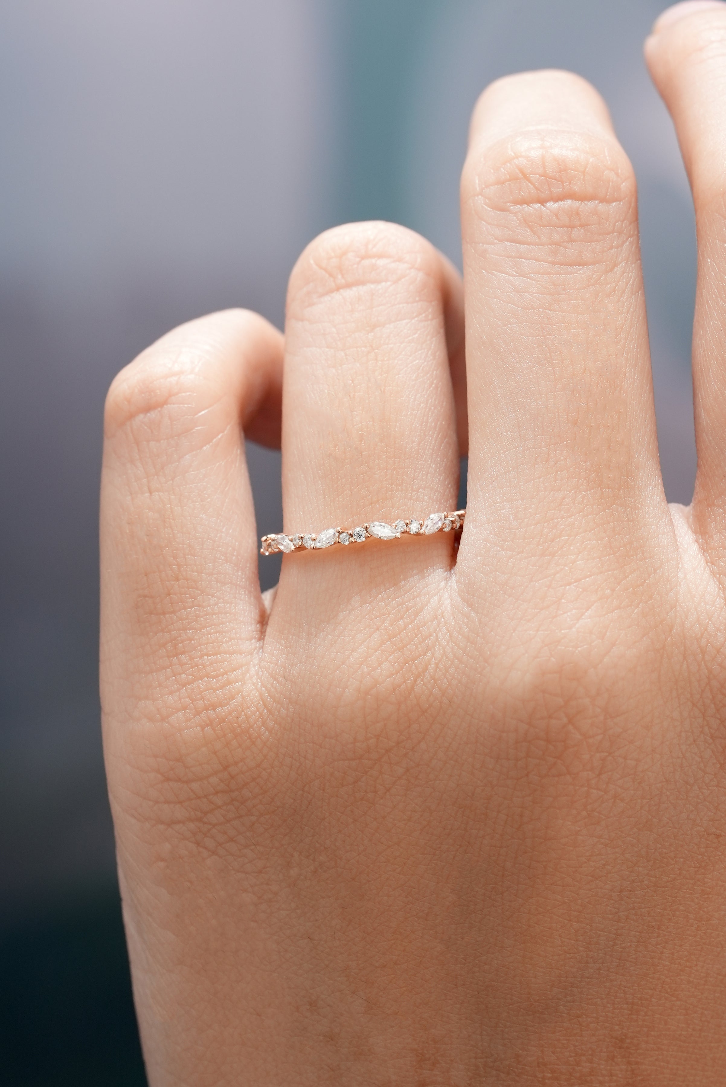 Hand wearing marquise cut moissanite stacking band