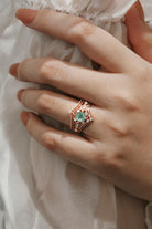 Rose gold moss agate engagement ring set. Moissanite accents, vintage bridal set, wedding band. Hand in focus.