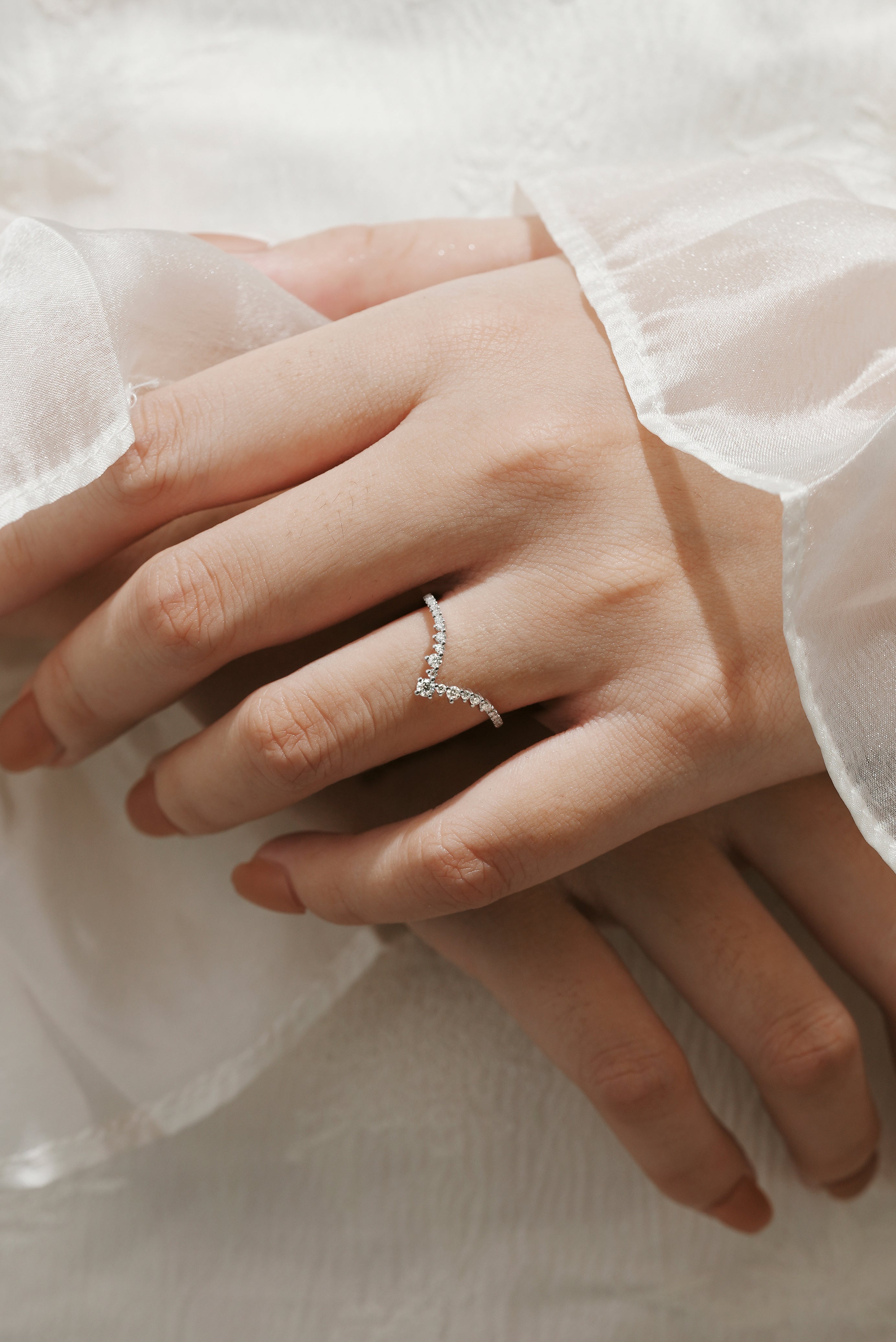 Moissanite V-shaped wedding band on a hand, elegant and minimalist design