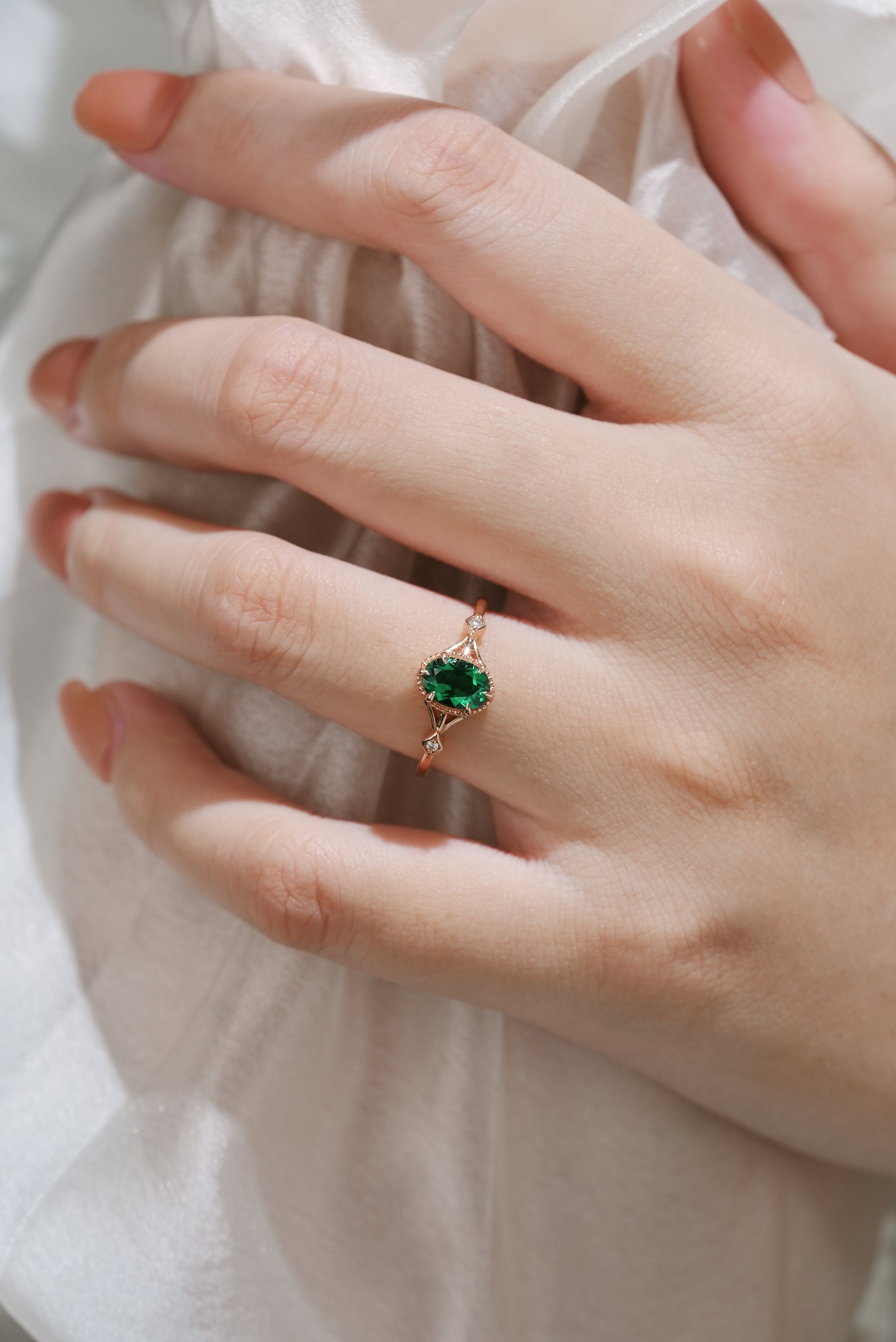 Emerald engagement ring on finger, nature inspired design
