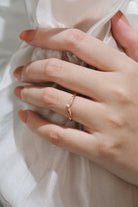Hand wearing V-shaped moissanite wedding band