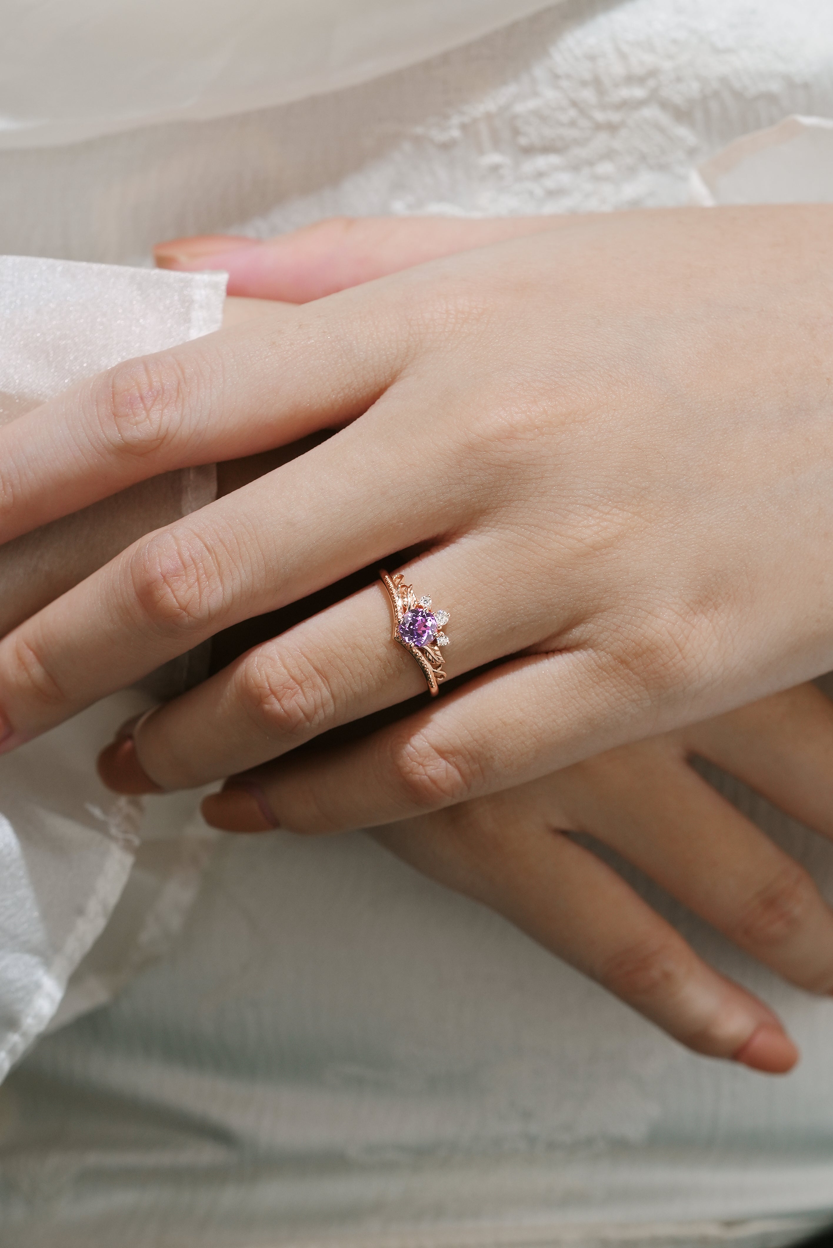 Woman's hand wearing a purple sapphire leaf engagement ring by Lahela Jewelry