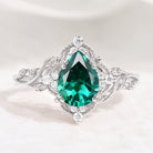 Nature-inspired pear cut lab emerald engagement ring with leaf detailing