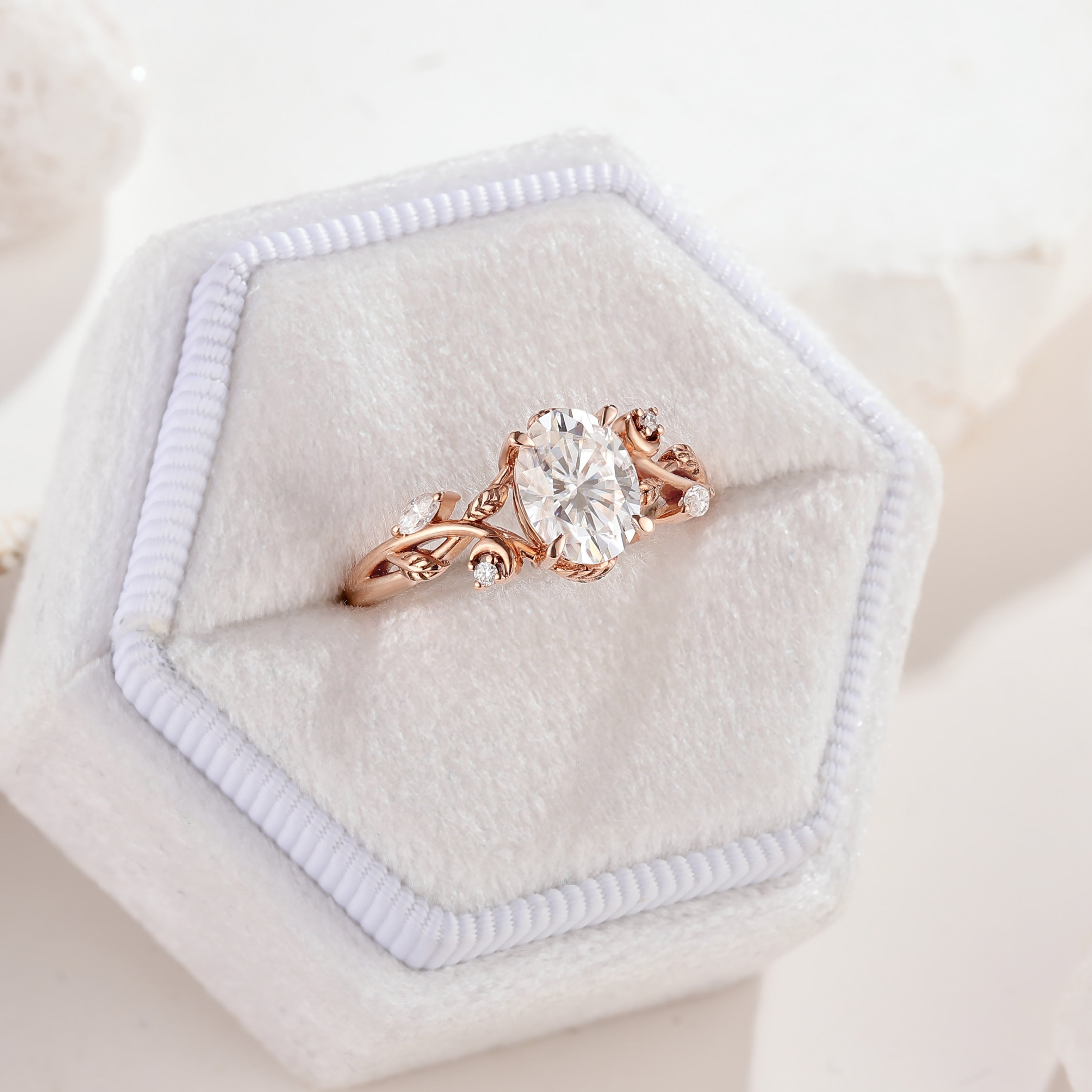 Nature Inspired Leaf Shaped Oval Moissanite Engagement Ring In A White Ring Box