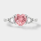 Pink heart-cut Padparadscha engagement ring with floral accents.