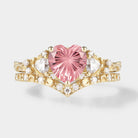 Heart-cut Padparadscha engagement ring set with a gold band and moissanite accents