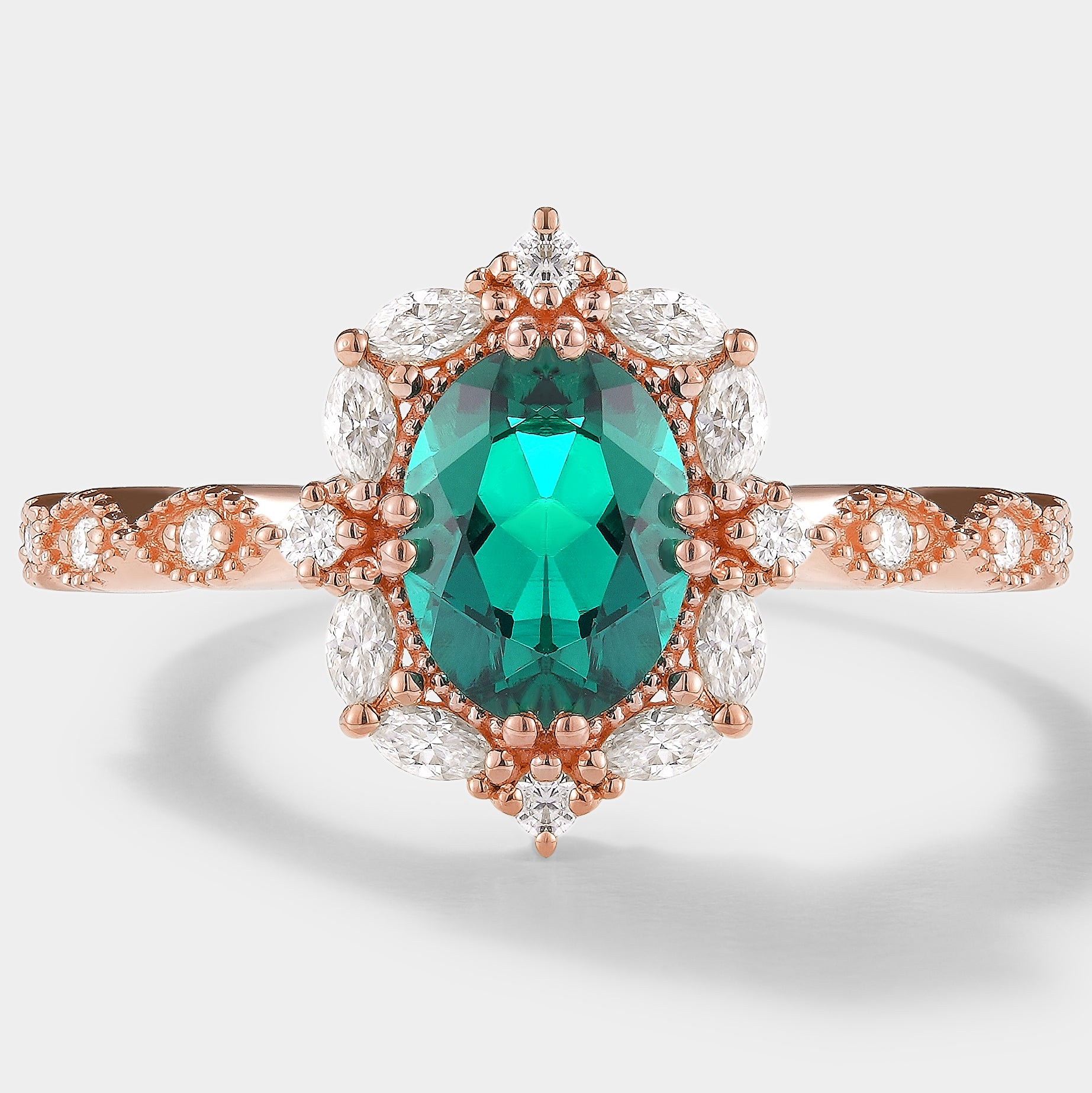 Rose gold emerald and moissanite engagement ring, oval cut
