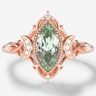 Marquise green sapphire engagement ring with moon motifs, vintage-style design in rose gold, accented with moissanite.
