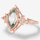 Rose gold marquise green sapphire engagement ring with moon motifs, moissanite accents, and vintage design