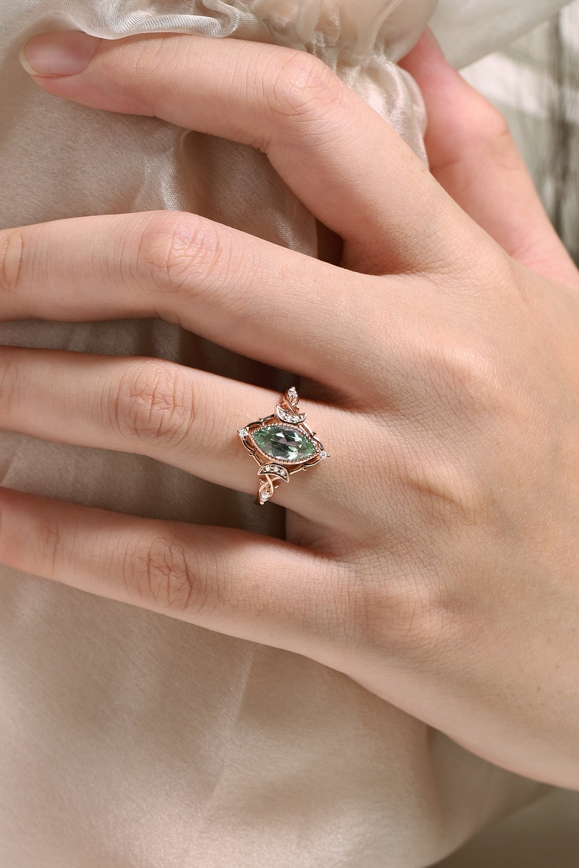 Marquise green sapphire engagement ring in rose gold, moon and moissanite accents, on hand, Lahela Jewelry