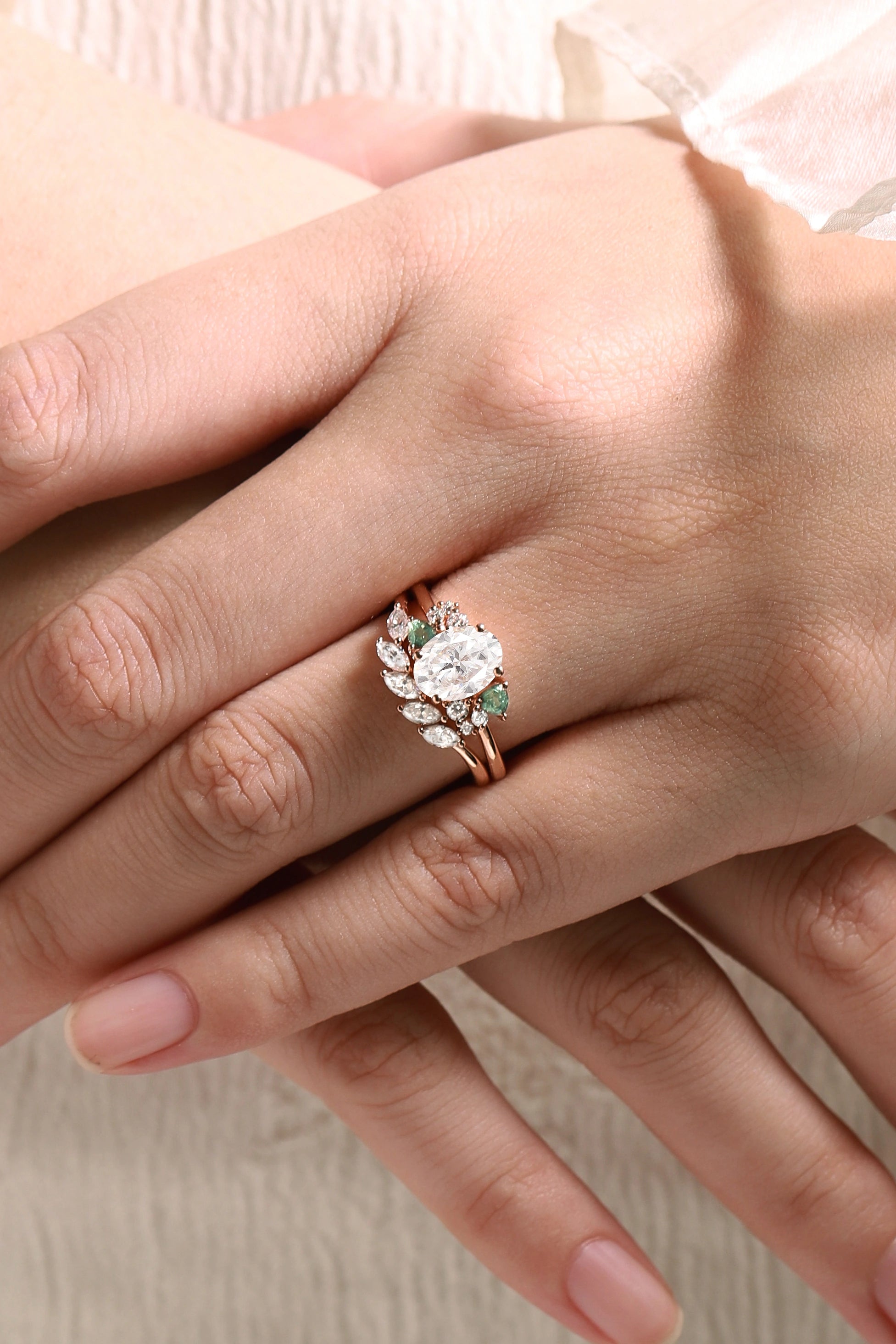 Rose gold oval moissanite engagement ring with triangle spinel accents on a hand. Bridal set ring.
