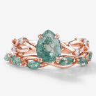 2-piece Moss Agate engagement ring set with pear-cut center stone and straight wedding band in rose gold. Bridal ring set.