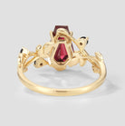Nature-inspired gold ring with coffin-cut ruby and leaf accents.