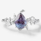 Pear Cut Alexandrite Leaf Engagement Ring in White Gold. A vintage engagement ring with leaf design and moissanite accents.