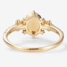 Back view of an oval-cut opal engagement ring in yellow gold, featuring a floral design, bridal set.
