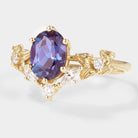 Oval cut alexandrite engagement ring with moissanite accents and floral design in yellow gold. Bridal ring set.