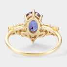 Oval alexandrite engagement ring in yellow gold, with moissanite accents, showing intricate floral design. Wedding ring