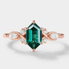Rose gold ring with hexagon-cut lab-grown emerald center stone, and moissanite accents. A unique vintage engagement ring.