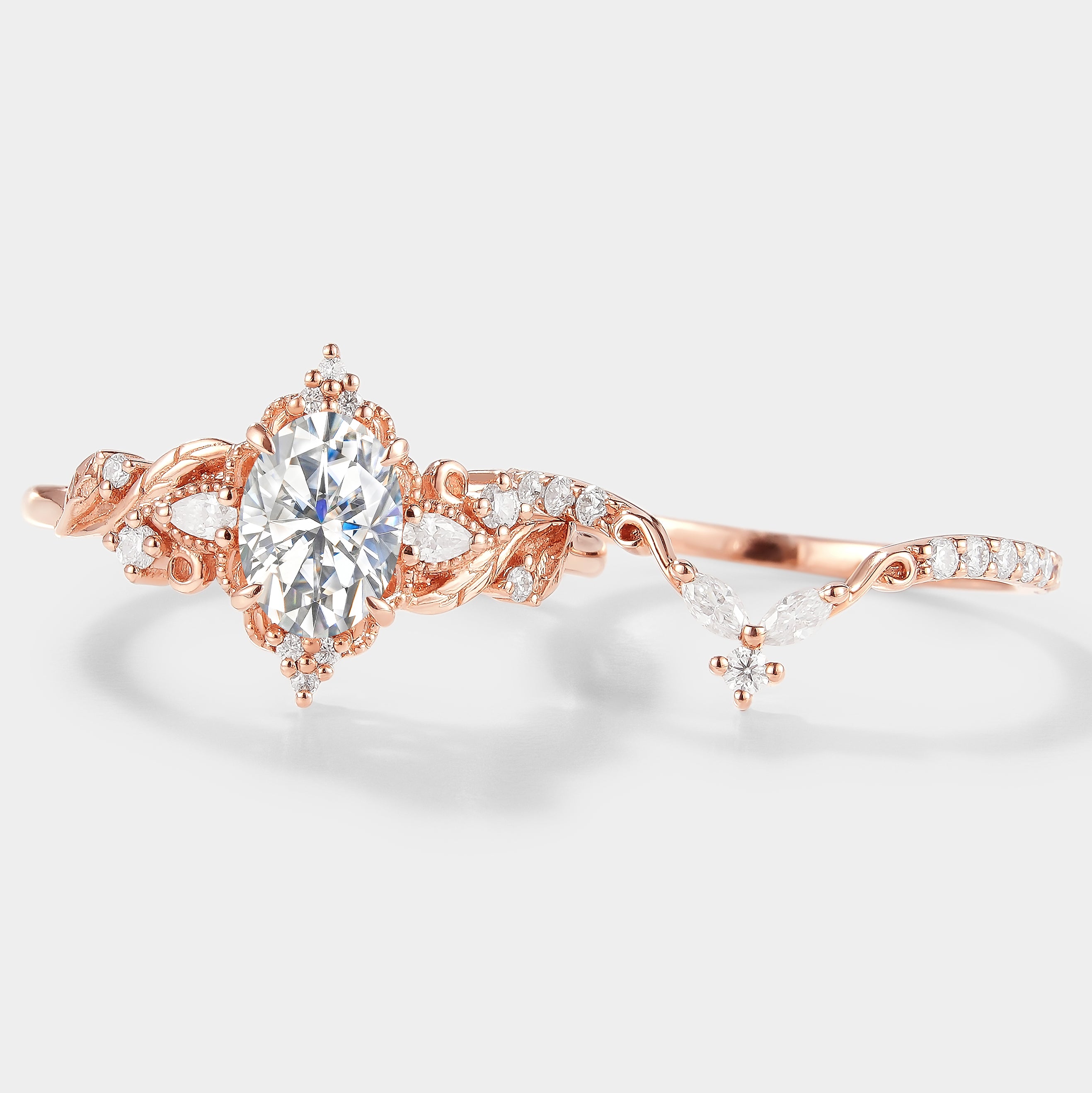 Rose gold leaf design moissanite ring set, engagement and wedding band. Bridal jewelry with oval cut center stone.