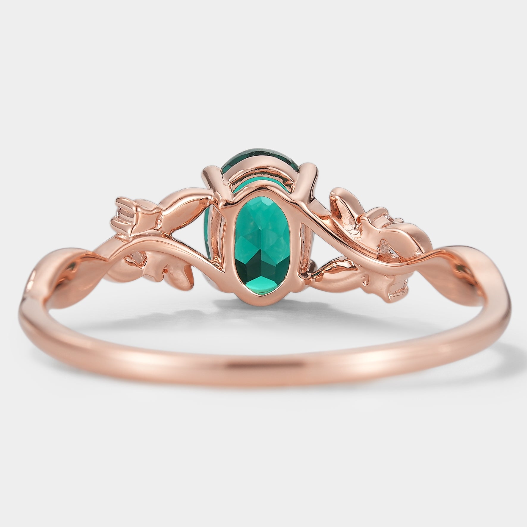 Oval lab grown emerald engagement ring with leaf design in rose gold. Wedding ring.