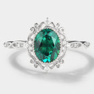 Vintage style lab grown emerald engagement ring, oval cut with moissanite accents, white gold band, royal court design.