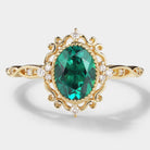 Vintage lab-grown emerald engagement ring with moissanite accents in a yellow gold band.
