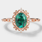 Vintage lab grown emerald engagement ring with moissanite accents in rose gold.