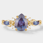 Classic pear-cut alexandrite engagement ring with leaf design, gold band, moissanite accents. Lahela Jewelry